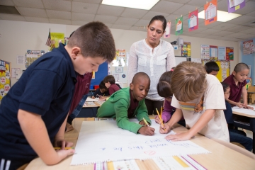 Kindergarten teacher watching her class at work.