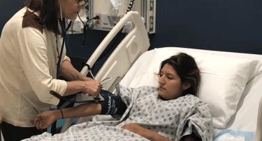 Woman in hospital bed with carer