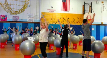 Students drumming in gym