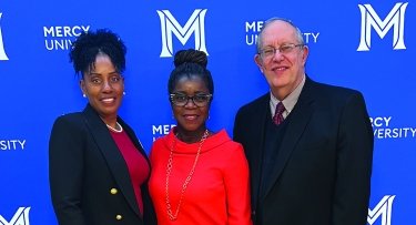 School of Nursing Dean Kenya Beard, nursing executive Launette Woolforde and School of Business Dean Lloyd Gibson standing in front of a Mercy University step and repeat banner.