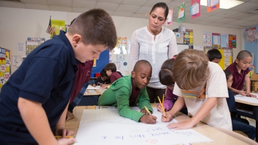 Kindergarten teacher watching her class at work.