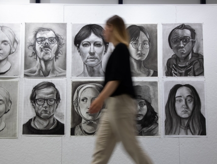 Student walking past drawings