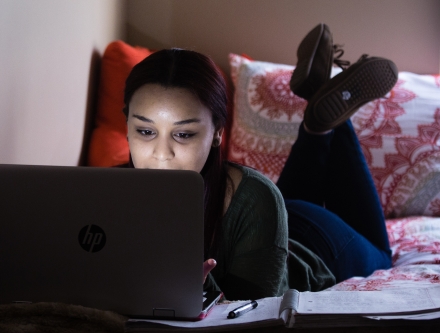 Working on laptop in dorm room.