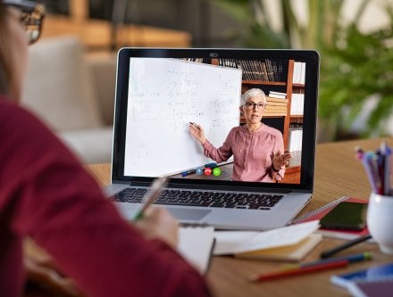 This is an image of a student watching a professor teaching online.